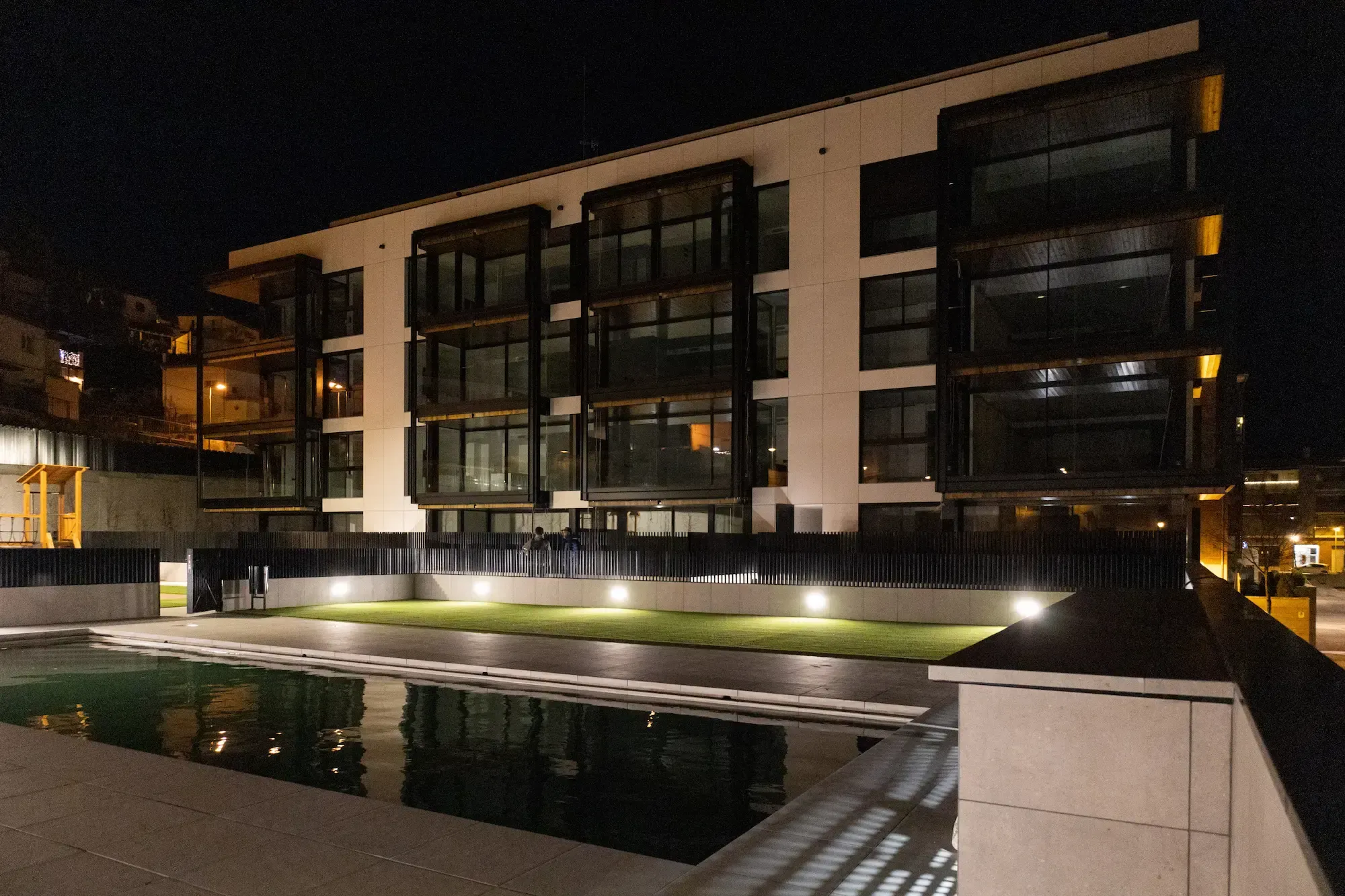 Promoción entregada de Edificaciones Moreno con piscina, al anochecer