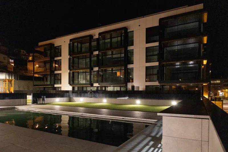 Promoción entregada de Edificaciones Moreno con piscina, al anochecer
