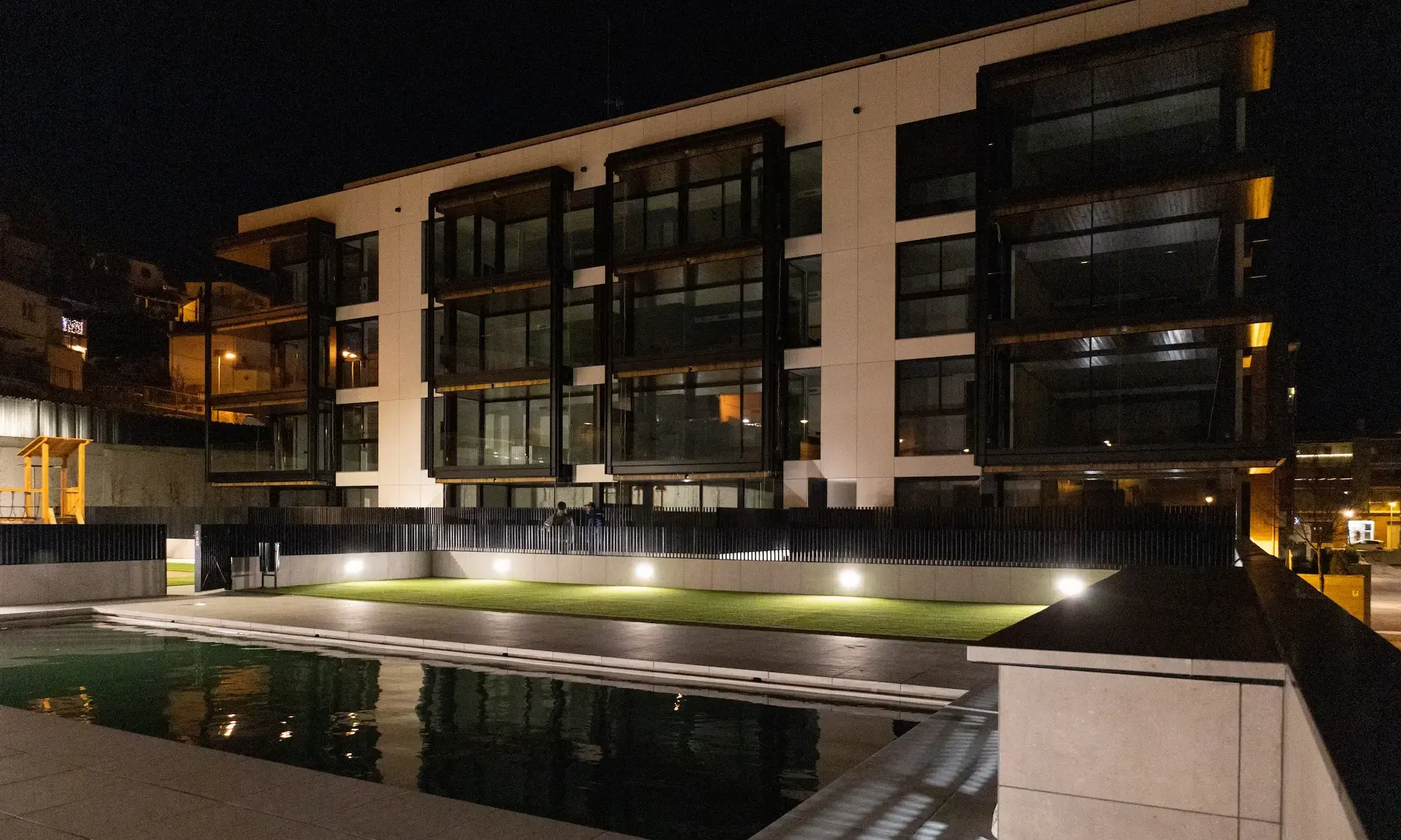Promoción entregada de Edificaciones Moreno con piscina, al anochecer